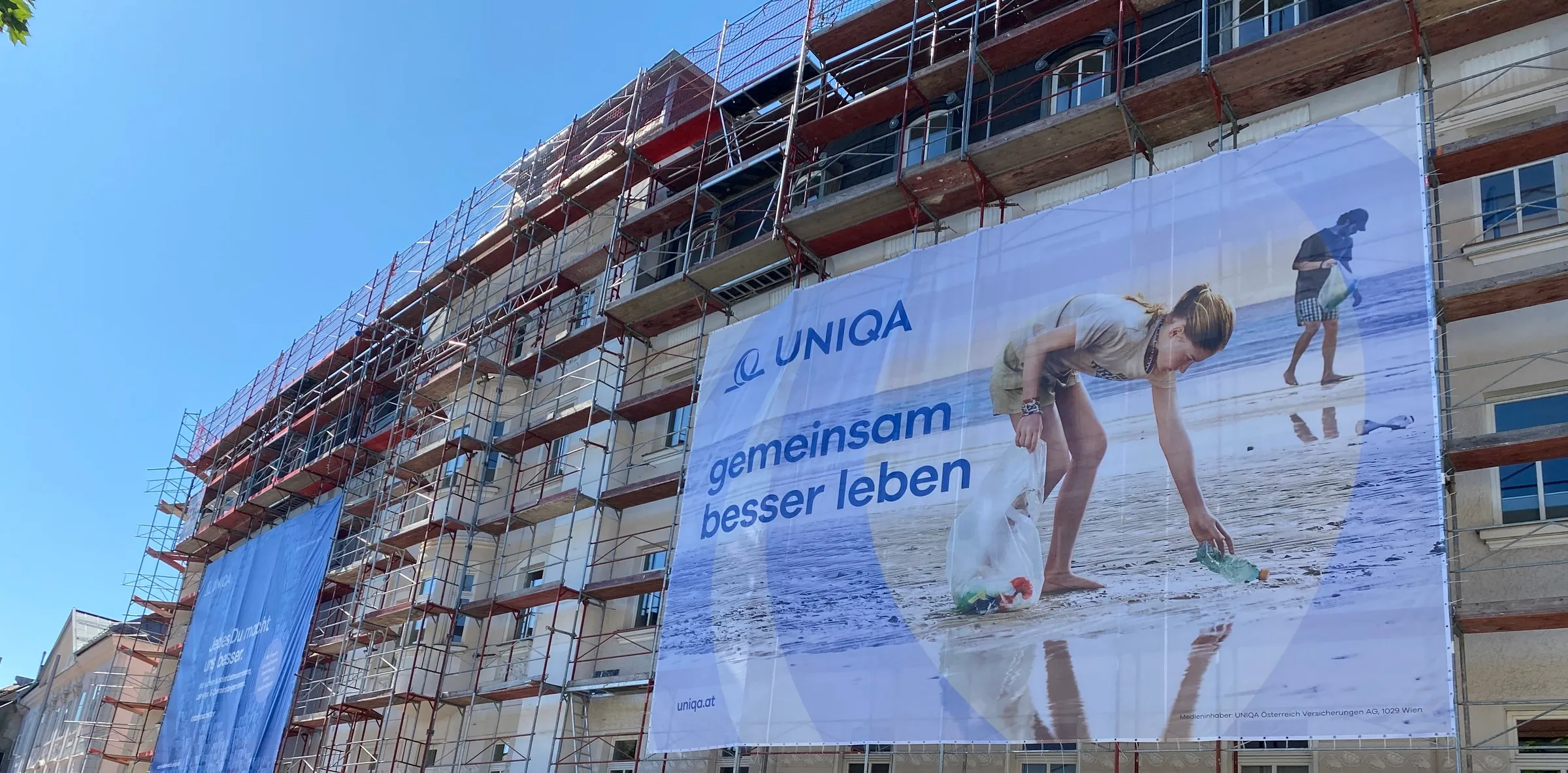 Zwei große Mesh-Banner am Baugerüst eines Stadthauses