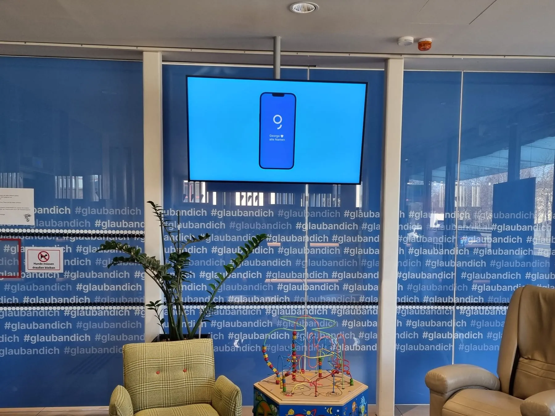 Glaswand in einer Filiale der Kärntner Sparkasse mit bedruckter Folie zur Kampagne #glaubandich