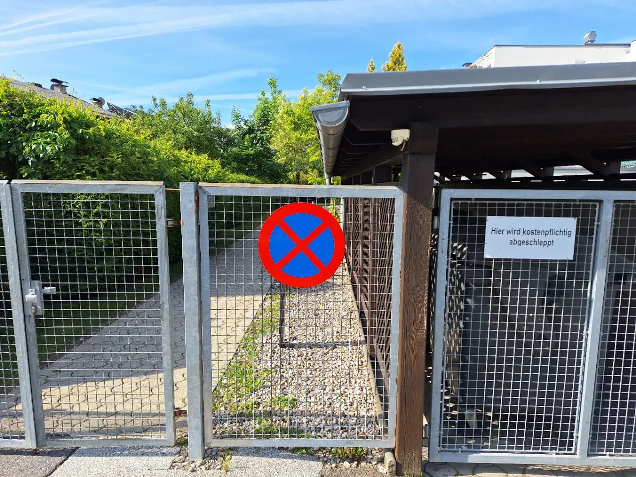 Halteverbot mit Abschlepphinweis an einer Einfahrt