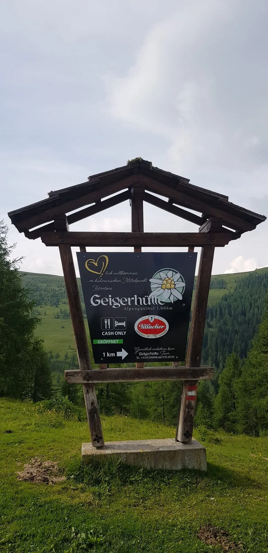 Hinweistafel zum Almgasthof im Holzrahmen