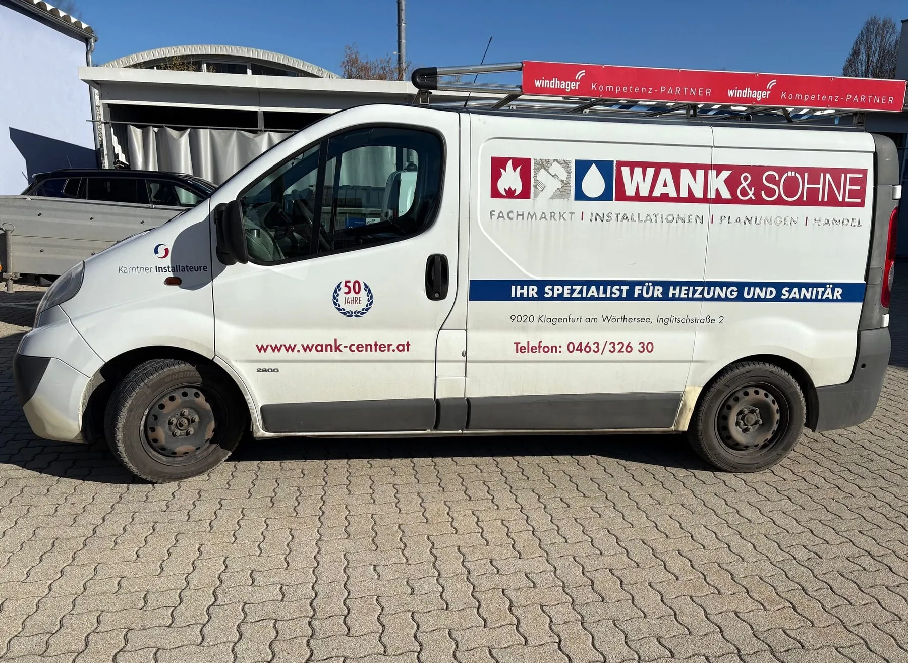 Kastenwagen von Wank & Söhne mit Seitenbeschriftung und Werbeschild auf dem Dachträger