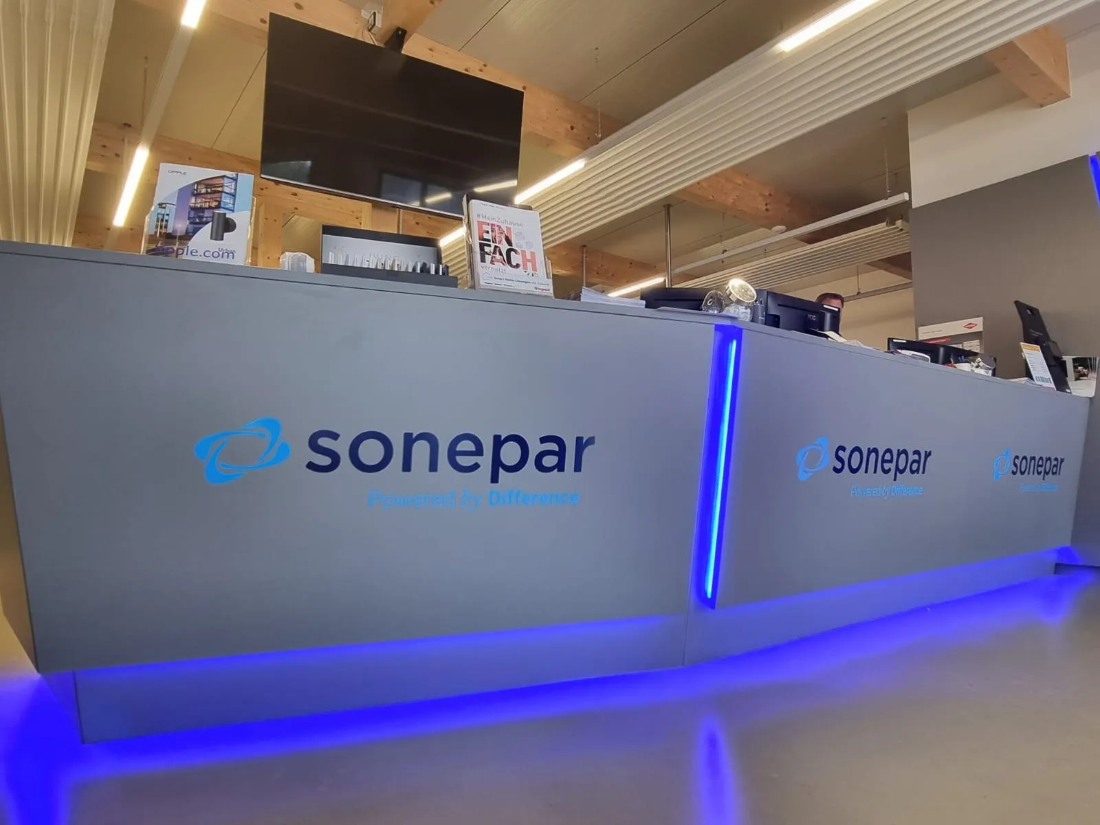 Empfangstheke von Sonepar mit Logos und blauem LED-Band am Sockel