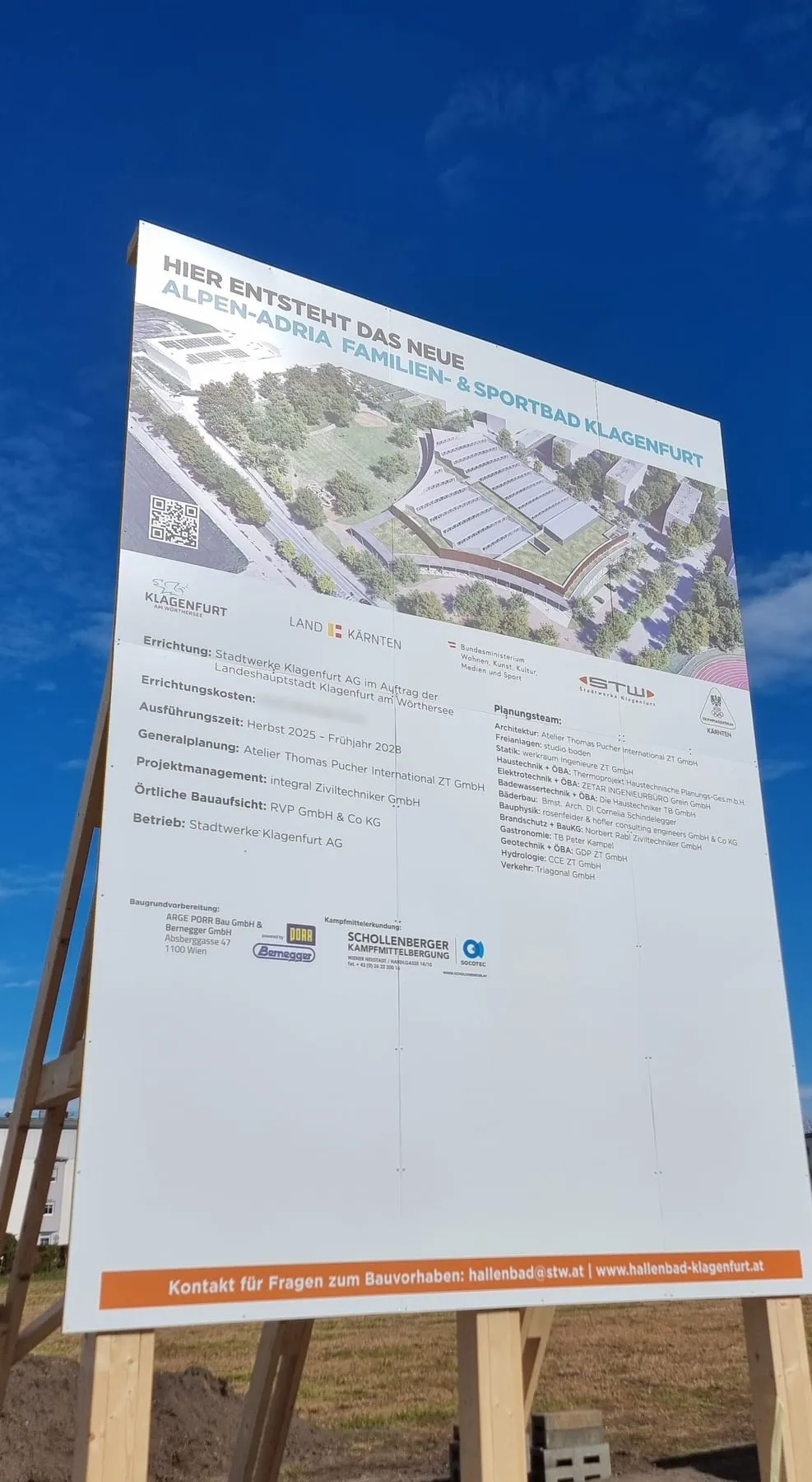 Bautafel für das neue Alpen-Adria Familien- und Sportbad der Stadtwerke Klagenfurt auf einem Holzgestell