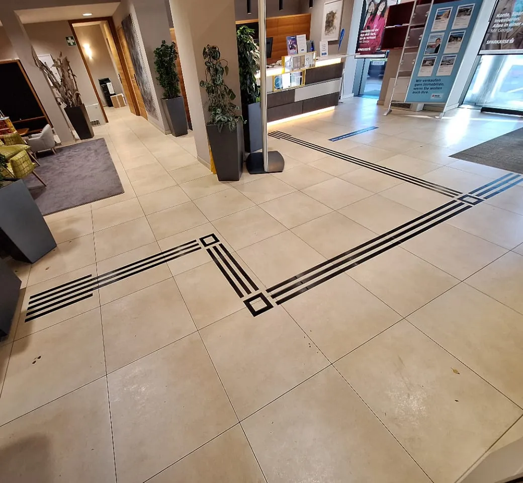 Leitstreifen mit Aufmerksamkeitsfeldern an den Abzweigungen im Foyer einer Sparkasse-Filiale