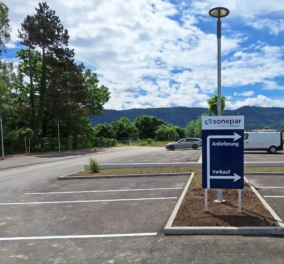 Freistehende Stele mit zwei Pfeilen zu Anlieferung und Verkauf auf einem Parkplatz